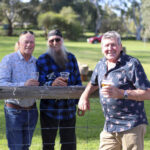 Photographie de trois hommes souriants